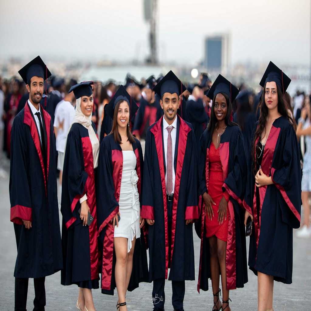 diverse group of happy international students celebrating graduation with colorful caps and gowns, modern university campus background, bright and energetic atmosphere